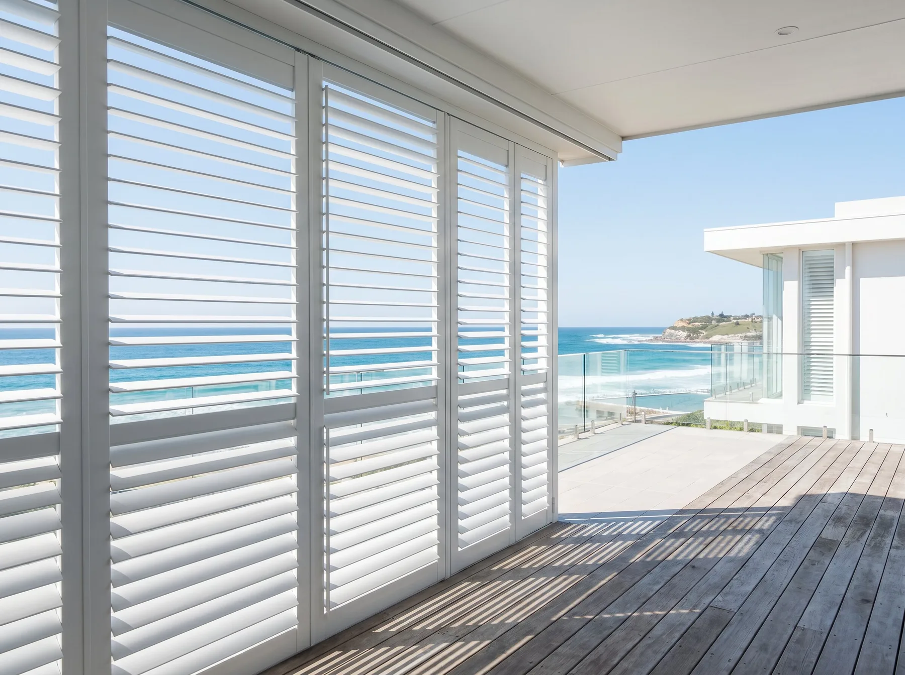 Powder-coated aluminium shutters on a coastal balcony